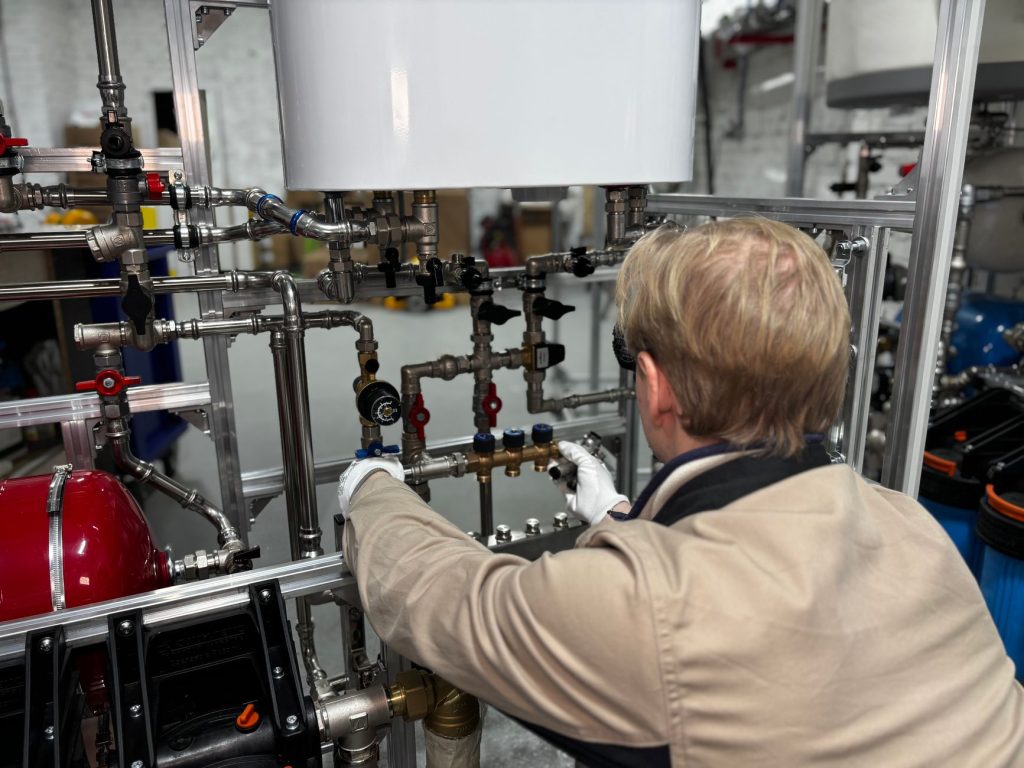 Technicien intervenant sur un réseau de tuyauteries de chauffage