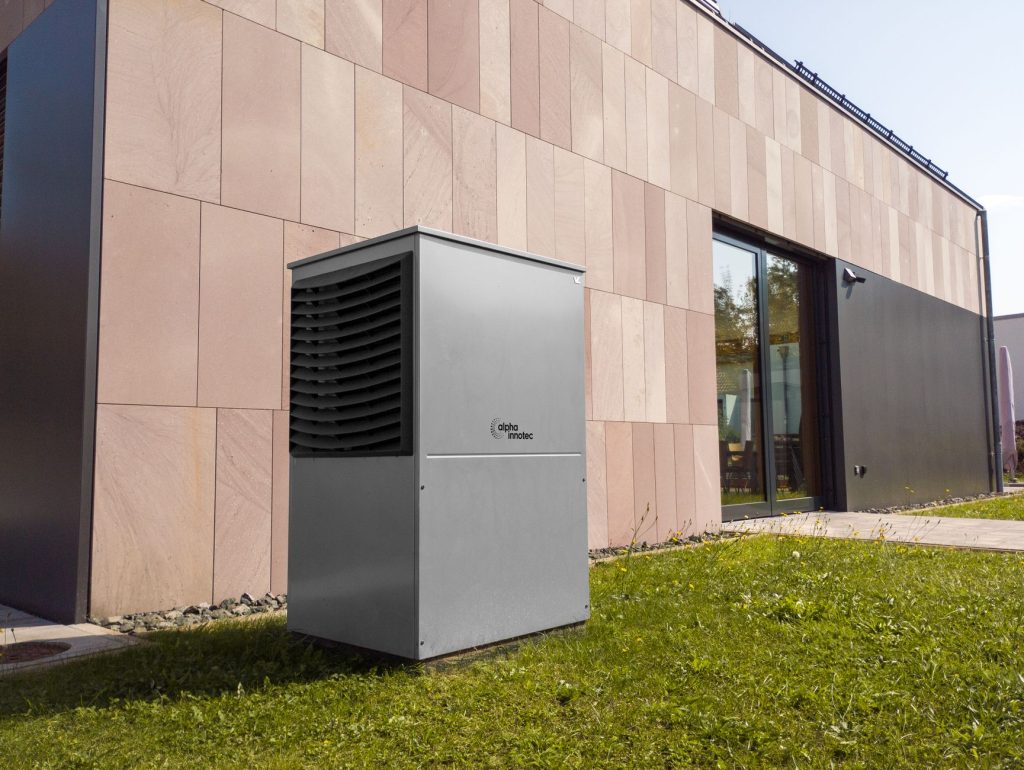 Unité extérieure de pompe à chaleur air-eau installée le long d’une maison
