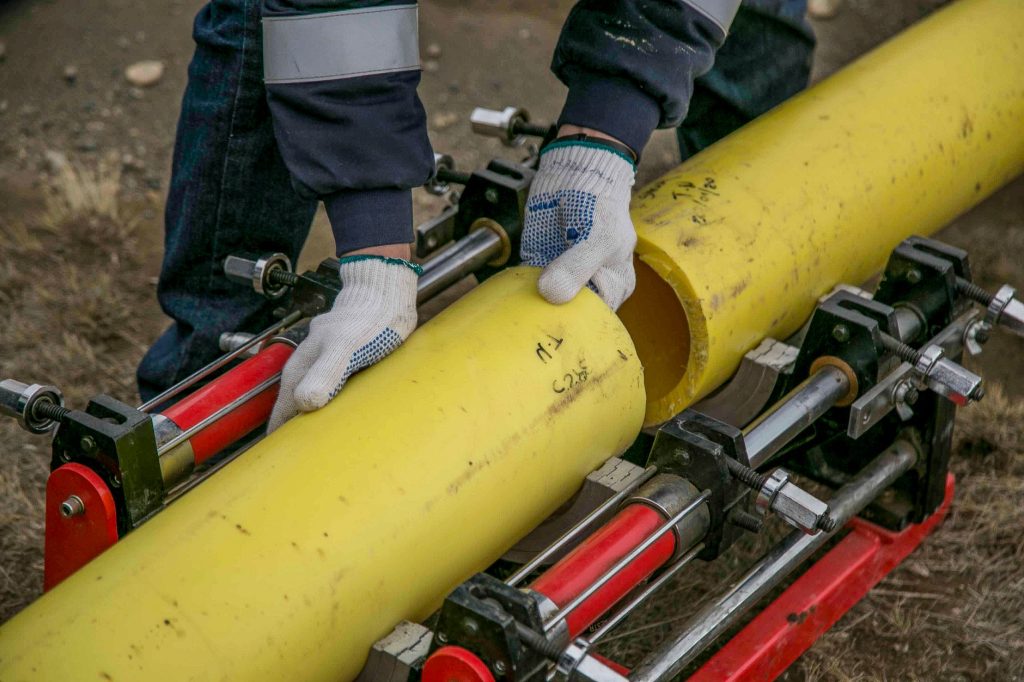 Plombier réparant une canalisation avec une clé à molette lors d'une intervention de dépannage