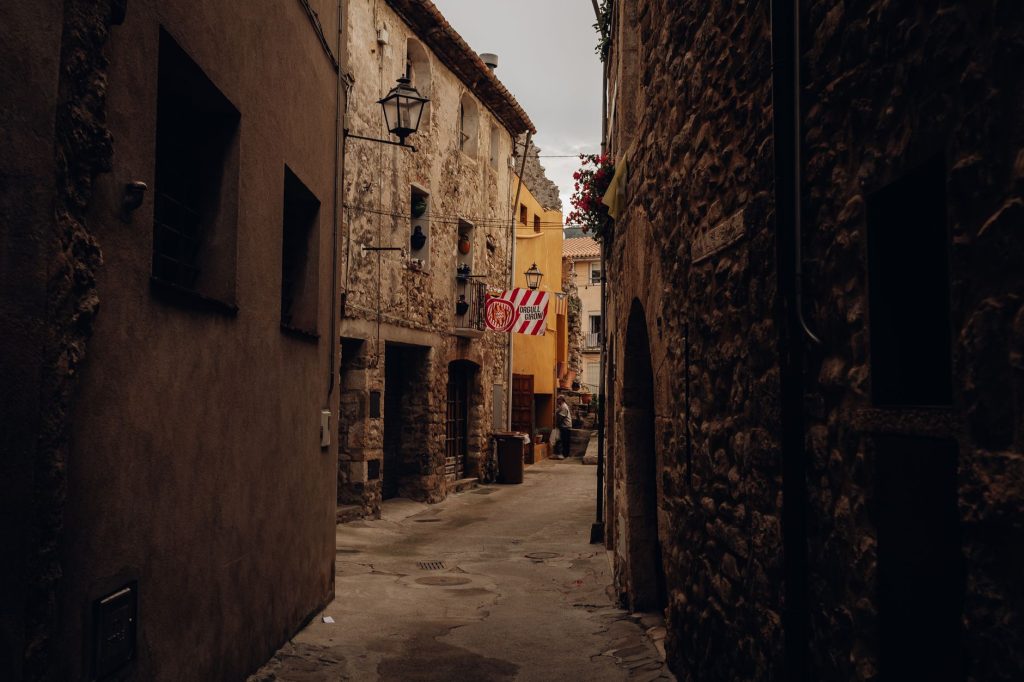 Ruelle de pierre bordée de façades anciennes dans un village catalan